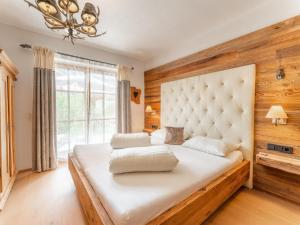ein Schlafzimmer mit einem großen Bett und einem großen Fenster in der Unterkunft Maier Alm in Wald im Pinzgau