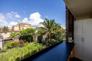 a balcony with a view of a house at Lumina - DestinationGuyane - Séjours d'affaires sur-mesure in Cayenne