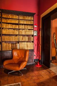una silla de cuero en una habitación con una gran biblioteca en Domus Laeta, en Giungano