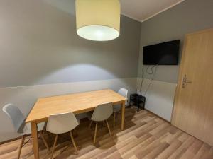 a dining room with a wooden table and chairs at Lullaby Private Rooms in Poznań