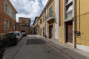 un callejón vacío con edificios y coches aparcados en la calle en Apartment Holiday Senigallia en Senigallia