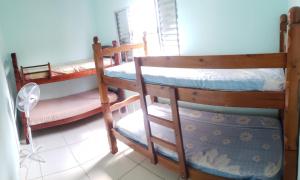 2 łóżka piętrowe w pokoju z wentylatorem w obiekcie Casa Pestana - Ilha Comprida w mieście Ilha Comprida