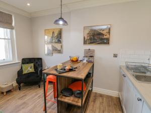 een keuken met een tafel en een stoel in een kamer bij Fenby Suite in Saltburn-by-the-Sea