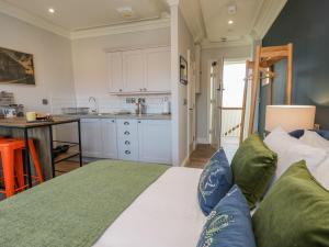 a room with a bed with a kitchen in the background at Fenby Suite in Saltburn-by-the-Sea