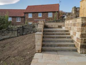 a stone retaining wall with stairs in a yard at Fenby Suite in Saltburn-by-the-Sea