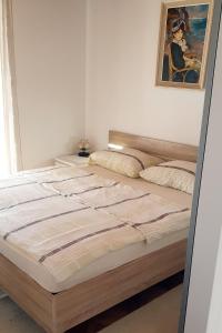 a bed in a bedroom with a painting on the wall at Apartments with a parking space Selce, Crikvenica - 5531 in Selce