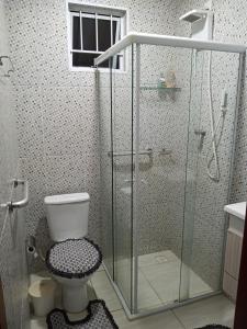 a bathroom with a toilet and a glass shower at Quarto Solteiro com TV in Artur Nogueira