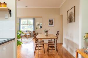 cocina y comedor con mesa y sillas en Pebbleton, Retro Riverside Cottage, Tamar Valley, en Gravelly Beach