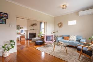 sala de estar con sofá y mesa en Pebbleton, Retro Riverside Cottage, Tamar Valley, en Gravelly Beach