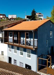 an apartment building with an orange roof and a balcony at Inn Door 21 - Hostel & Suite in Bragança