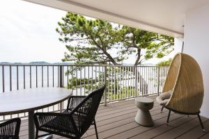 a balcony with a table and chairs on a deck at THE HARBOR TERRACE in Kotsubo