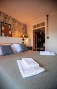 a bedroom with a large bed with two towels on it at Inn Door 21 - Hostel & Suite in Bragança