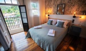 a bedroom with a bed with two towels on it at Inn Door 21 - Hostel & Suite in Bragança