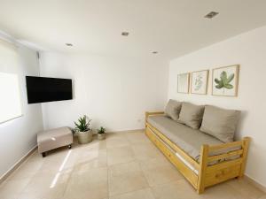 a living room with a couch and a flat screen tv at Casa Tila in Puerto Madryn