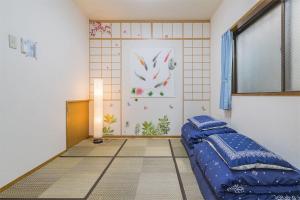 ein Schlafzimmer mit einem blauen Bett und einem Fenster in der Unterkunft Shinjuku12min Shibuya15min Max10ppi Free-Wifi in Tokio