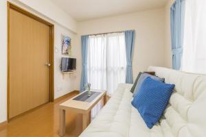 a living room with a white couch and a table at Shinjuku12min Shibuya15min Max10ppi Free-Wifi in Tokyo