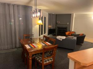 una sala de estar con una mesa y un sofá en Condo Lac Archambault 316, en Saint-Donat