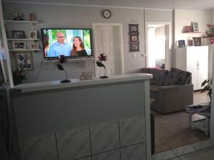 uma sala de estar com uma televisão de ecrã plano na parede em Residência El Shaday em Gramado
