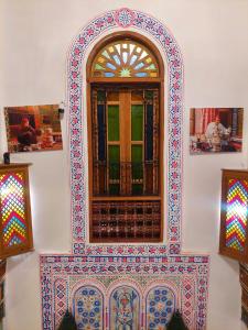 a window with colorful tiles on a wall at Palais Fes Yahya in Fès al Bali