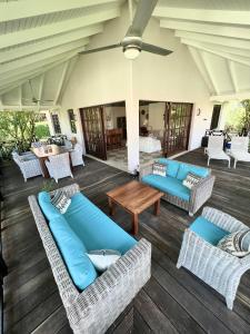 a patio with blue couches and a table and chairs at Vrijstaande BB BEACH Villa Azure in Blue Bay