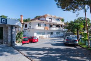 due auto parcheggiate di fronte a una grande casa di Apartments with swimming pool Opatija - Pobri, Opatija - 16390 a Matulji (Mattuglie)
