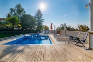 una piscina su una terrazza in legno con 2 sedie di Apartments with swimming pool Opatija - Pobri, Opatija - 16390 a Matulji (Mattuglie) Altre 11 foto