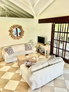 een woonkamer met twee witte banken en een tafel bij Vrijstaande BB BEACH Villa Azure in Blauw Baai