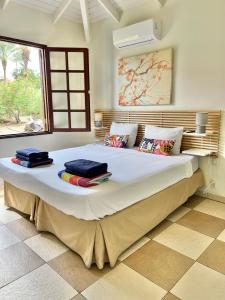 1 dormitorio con 1 cama grande y toallas. en Vrijstaande BB BEACH Villa Azure, en Blue Bay