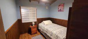 a small bedroom with a bed and a window at Cabañas IBY y KIARA para 4 en Puerto Varas in Puerto Varas