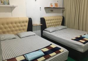 two beds sitting in a room withskirts at LORENT HOSTEL in Kampungdurian