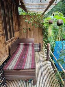 un banco de madera sentado en una terraza de madera en Kuba Bungalows en Ko Kood