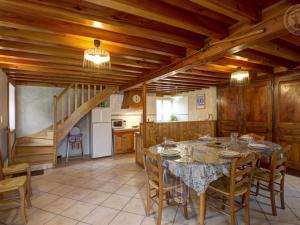 Una cocina y un comedor con mesa y sillas. en Gîte spacieux avec terrasse, poêle à bois, parking privé, et jardin fermé, animaux acceptés - FR-1-496-28, en Saint-Bonnet-le-Courreau