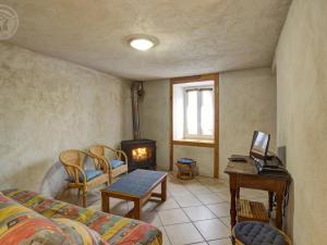 sala de estar con sofá y estufa de leña en Gîte Saint-Bonnet-le-Courreau, 4 pièces, 8 personnes - FR-1-496-28, en Saint-Bonnet-le-Courreau
