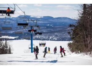 un grupo de personas en un remonte en la nieve en Condo Lac Archambault 305 en Saint-Donat-de-Montcalm