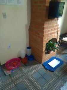 sala de estar con chimenea de ladrillo y TV en Du vadinho hotel en Lima Duarte