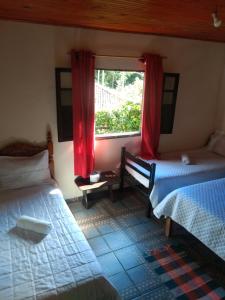 利馬杜阿奇的住宿－Du vadinho hotel，一间卧室设有两张床,窗户配有红色窗帘