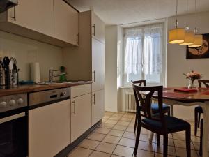 uma cozinha com mesa e cadeiras e uma janela em Bastis Family Apartment em Lucerna