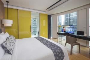 a bedroom with a bed and a desk with a computer at Citadines South Chengdu in Chengdu