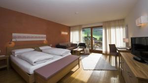 a hotel room with a bed and a television at Hotel Monte Sella in San Vigilio Di Marebbe