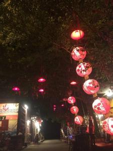 a group of pink lanterns hanging over a street at night at Gold Coast Morib Seaview 2 rooms Aircond Apartment in Banting