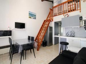 uma cozinha e sala de estar com uma mesa e uma escada em Appartement Saint-Cyprien, 2 pièces, 4 personnes - FR-1-309-353 em Saint-Cyprien