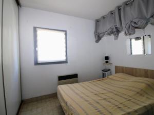 mała sypialnia z łóżkiem i oknem w obiekcie Saint-Cyprien - T2 Mezzanine avec Terrasse et Garage - FR-1-309-353 w mieście Saint-Cyprien