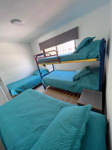 a bedroom with two bunk beds with blue sheets at Genial Casa en Bahía Inglesa in Bahia Inglesa