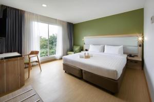 um quarto de hotel com uma cama grande e uma janela em Prime Square Hotel em Chiang Mai