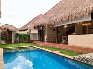 a house with a swimming pool in front of it at Alizee Villa in Seminyak
