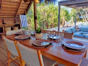 una mesa de madera con platos y copas de vino. en Villa Oemodo 3 bedrooms, en Nembrala