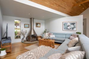 sala de estar con sofá azul y chimenea en Smuggler's Hideaway, riverfront Tamar Valley, en Blackwall