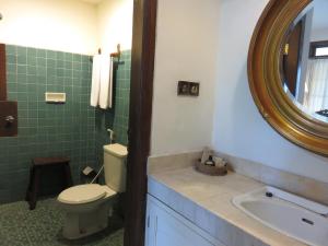 a bathroom with a toilet and a sink and a mirror at Hotel Tugu Blitar in Blitar