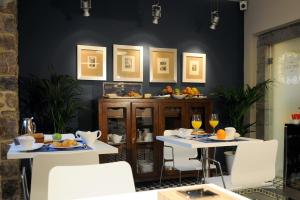 a dining room with two tables and white chairs at Antiguo Casino Hotel in Pravia