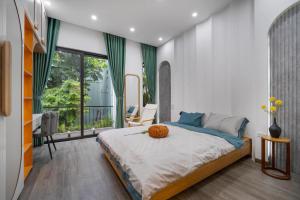 a bedroom with a large bed and a large window at Gạo House Homestay Đà Nẵng gần sân bay và trung tâm thành phố in Da Nang
